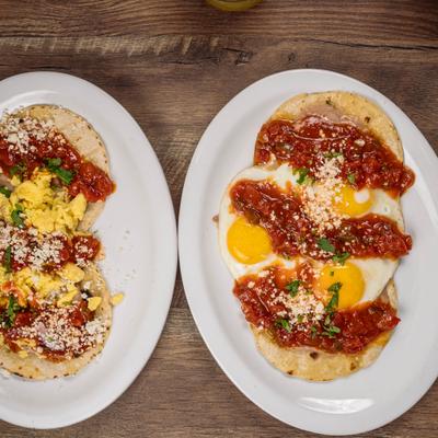 Huevos Rancheros and Breakfast Tacos, served on the table.