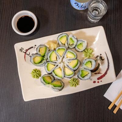 Avocado roll serrved with wasabi, dipping sauce and sake.