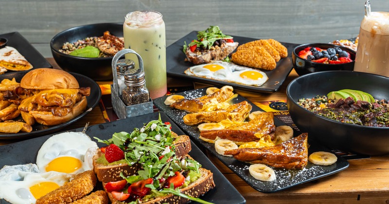 Stack of pancakes topped with banana, whipped cream and sprinckles