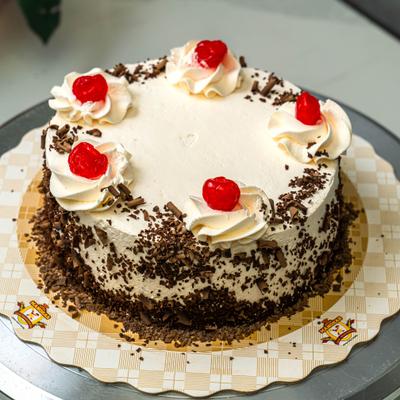 Black Forest cake with whipped cream, chocolate shavings, and bright red cherries.