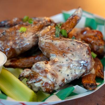 Garlic Wings served with celery sticks and a dipping sauce, close-up.