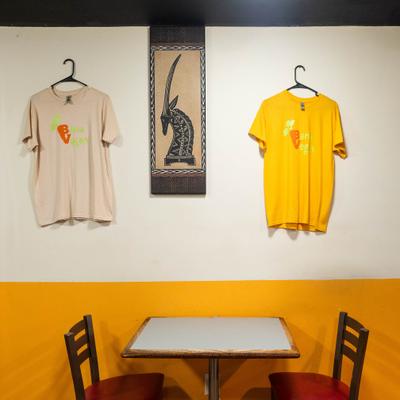 Restaurant merchandise on the wall alongside African-style wall art.