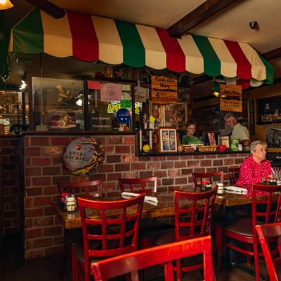 Interior with Italian-themed decoration and several patrons seated in dining area.