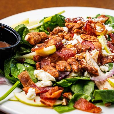 Spinach salad with bacon, glazed pecans, apple slices, and cheese.