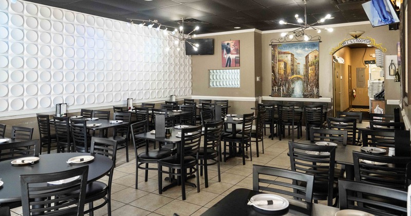 Modern restaurant interior with black tables and a white textured wall