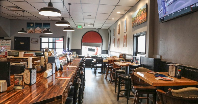 Interior, tables and chairs lined up on the right, bar and bar stools on the left