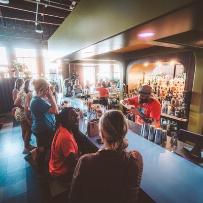 Interior, guests by the bar counter, bartender in action