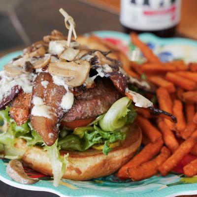 Mushroom Swiss Melt burger served with crispy sweet potato fries.