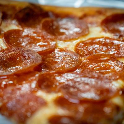 Extreme close up view of a pepperoni pizza slice.