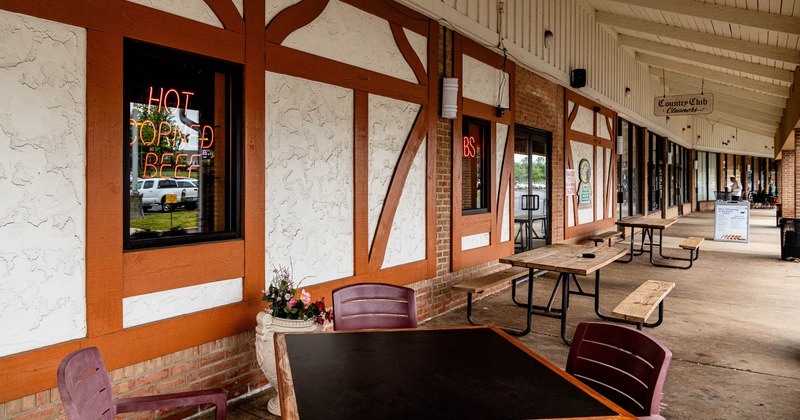Outdoor seating area with neon signs and rustic decor