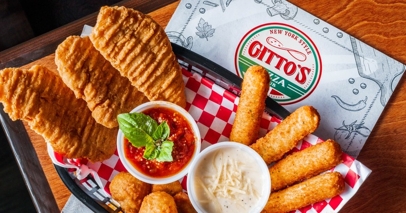 Appetizer platter featuring mozzarella sticks, chicken tenders, and dipping sauces