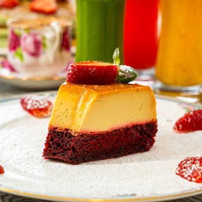Slice of Red Velvet Flan Cake garnished with strawberries.