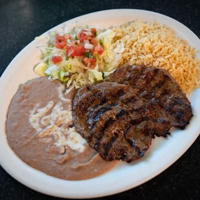 Grilled steak, served with lettuce, pico de gallo, rice, and refried beans.