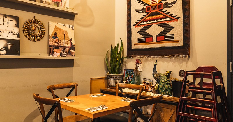 Restaurant interior, table set for four guests, wall decorations