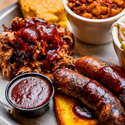 Sausage link over toast and Pork with BBQ sauce, Baked Beans & Apple Slaw, close up.