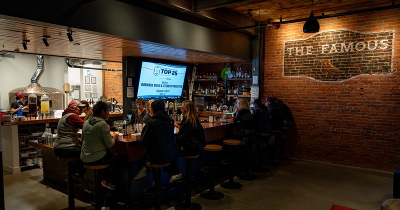 Interior with tables and chairs with tv screens on wall