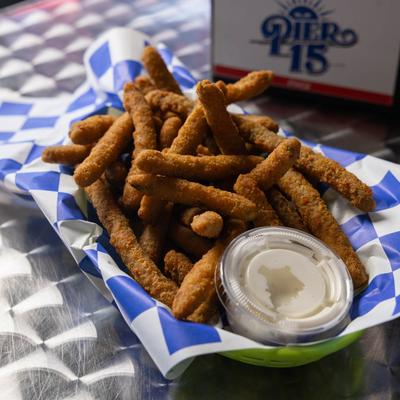 Fried green beans and ranch on checkered paper.