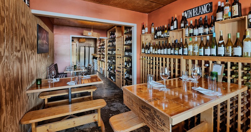 Interior, wine racks beside wall, tables and seats