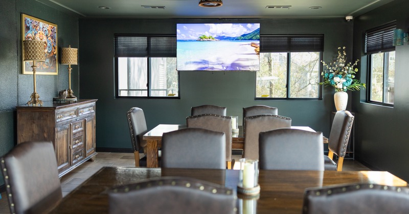 Interior, elegant dining space with green walls, decor and TV screen