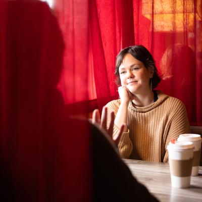Person sitting at the table with coffee cups.