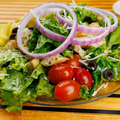 Joanie's Italian Salad with tomato, red onion, artichokes, black olives, cheese and croutons.