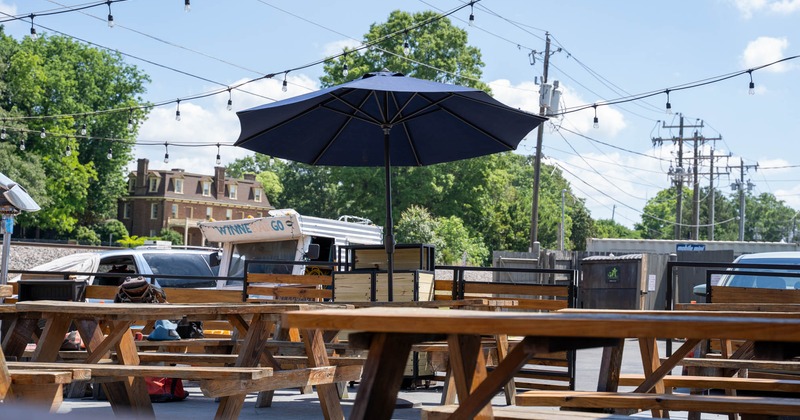 Exterior, patio, wooden tables with benches, lanterns, parasol