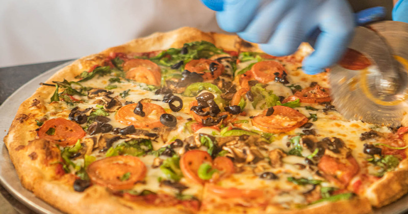 A chef slicing a pizza