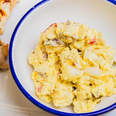 Potato salad in a white bowl.