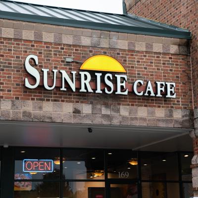 Sunrise Cafe exterior sign with yellow sun.