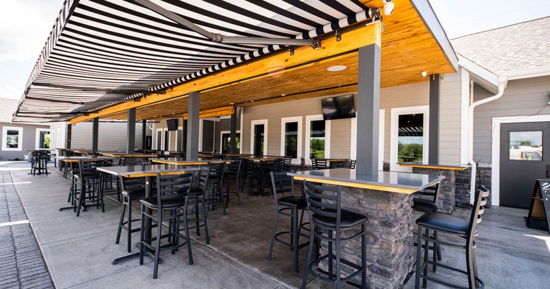 Exterior, covered patio area, tables with bar chairs