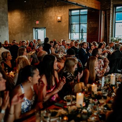Banquet room with guests sitting at tables at an event.