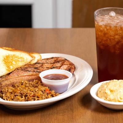 Tomahawk pork chop, with rice, toast, mac and cheese, and iced tea.