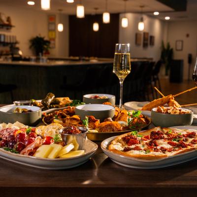 Various food and a glass of sparkling wine on the table.