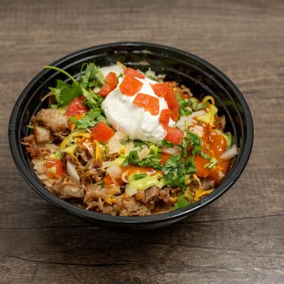 Burrito bowl with shredded pork, cheese, cilantro, sour cream, and diced tomatoes.
