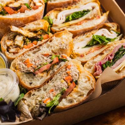 Catering sandwich platter featuring assorted baguette sandwiches.