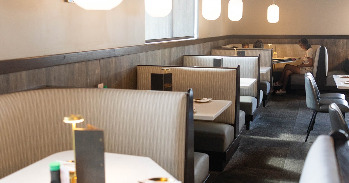 A cozy restaurant interior featuring beige curved booths