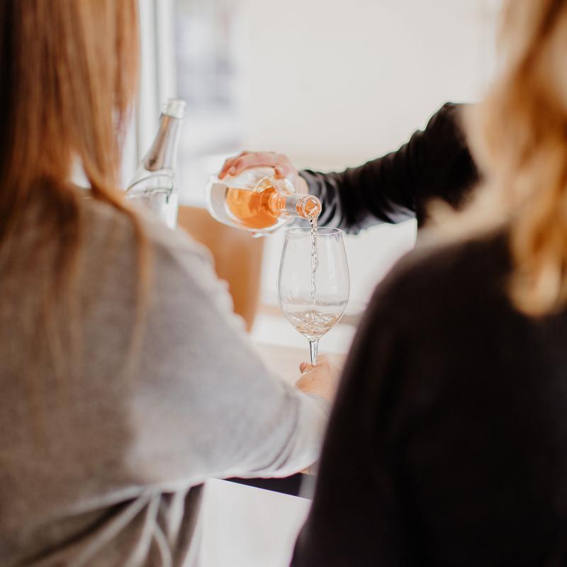 Person pouring rose wine at the wine tasting event.