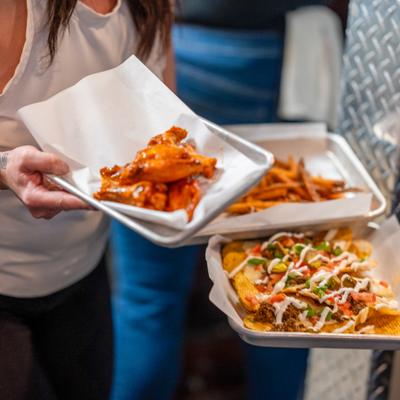 Server holding three plates of food.