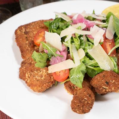 Milanese style pork rib with a salad and lemon.