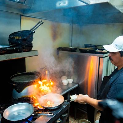 Chef preparing food in a pan.