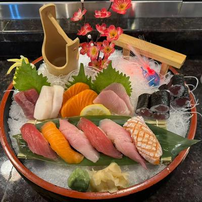 Sashimi platter features a variety of raw fish, several pieces of nigiri sushi and maki rolls.