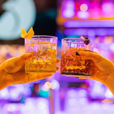 Bar area, cheers with cocktails, close-up