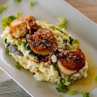 Seared scallops served over creamy risotto.