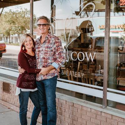 Portrait of the owners standing in front of the restaurant