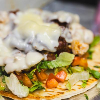 Cajun Bacon Chicken Pita topped with melted cheese, close-up.