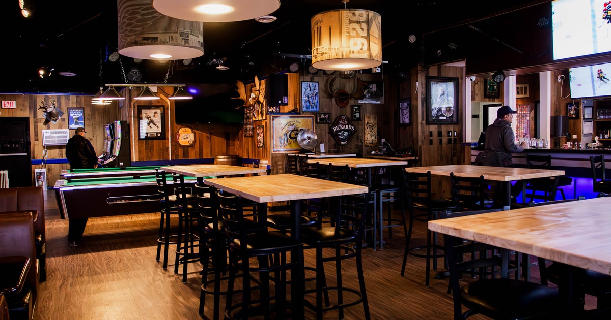 Interior, high seating area, wooden top tables with stools, various posters