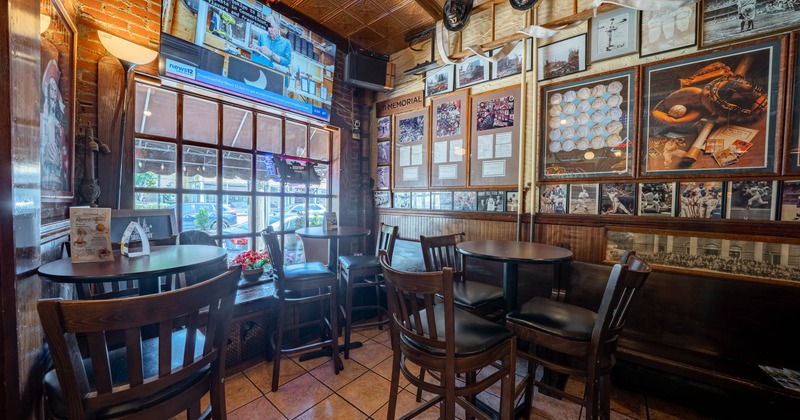 Interior with wooden furniture and framed memorabilia on the brick walls