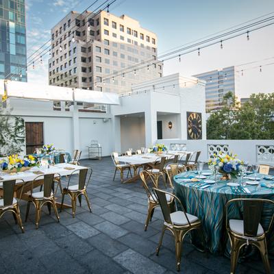 Tables and chairs outside on the patio, neighboring buildings.