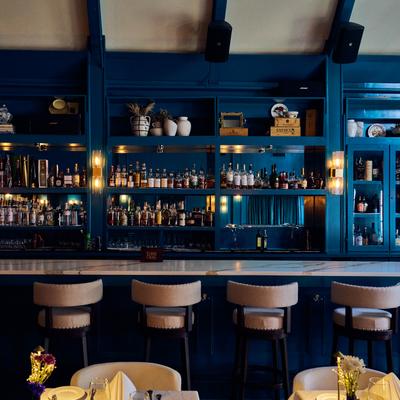 Blue bar shelves with stools below.