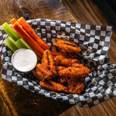 Chicken wings with celery, carrots, and ranch dipping sauce.